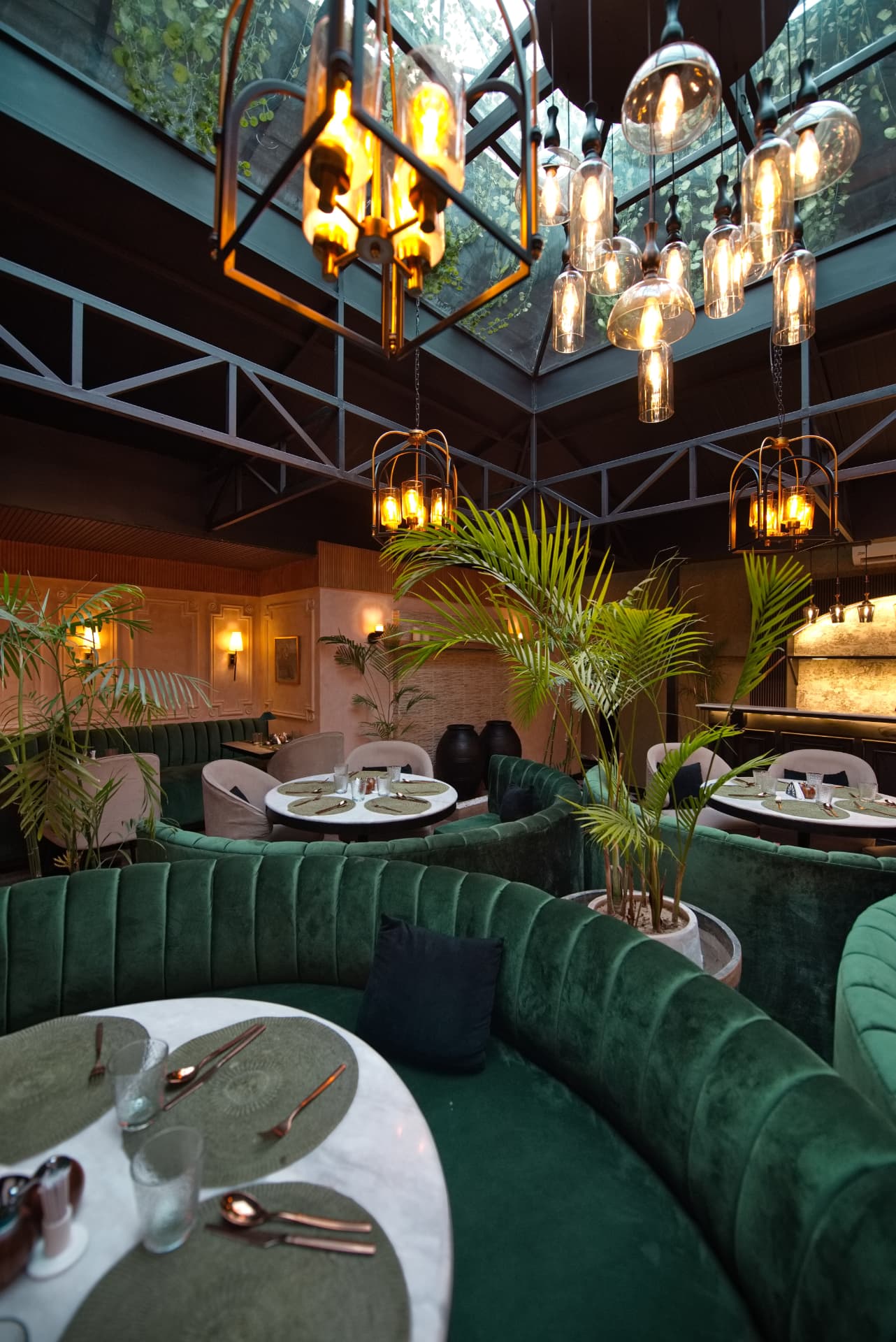 Emerald velvet seating under the glass-roofed dining room
