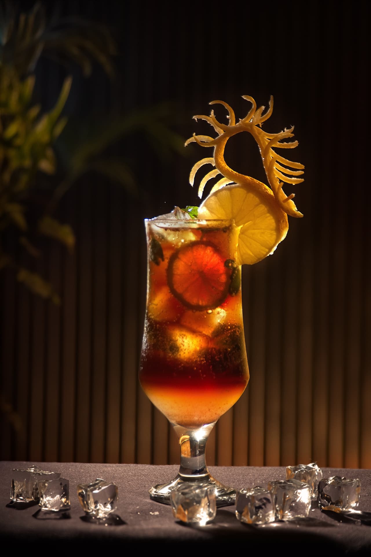 Mystique cocktail with citrus garnish against a dark background
