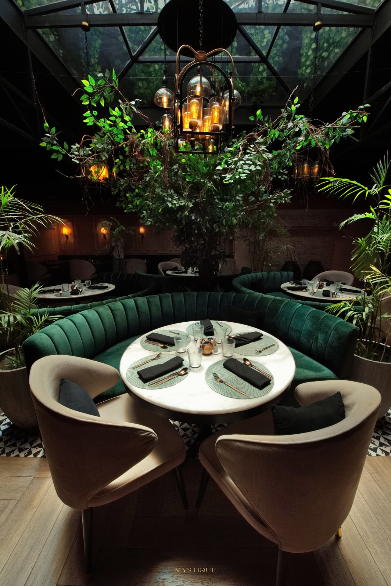 Emerald banquette and table beneath the atrium lanterns